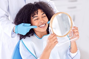 Dentist pointing to their patient’s brilliantly white teeth