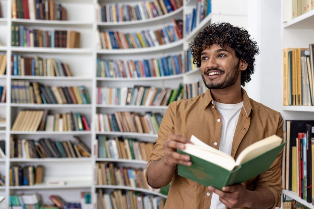 A man in a library reading a history book.